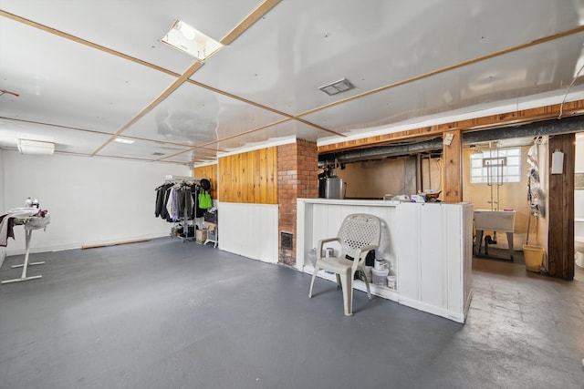 below grade area featuring water heater, a sink, and visible vents