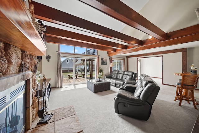 living area featuring carpet floors, beamed ceiling, and a fireplace