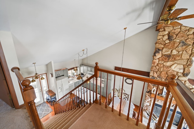 staircase with carpet, a ceiling fan, and lofted ceiling