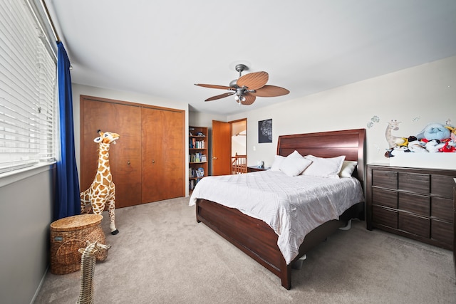 carpeted bedroom with ceiling fan and a closet