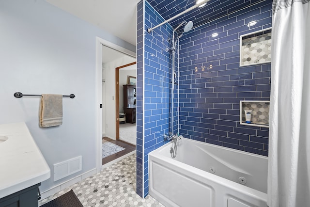 bathroom featuring vanity, a combined bath / shower with jetted tub, and visible vents