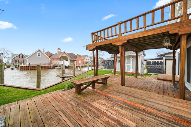wooden deck featuring a water view, a residential view, and a boat dock