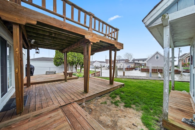 wooden terrace featuring a lawn, a water view, a grill, and a residential view