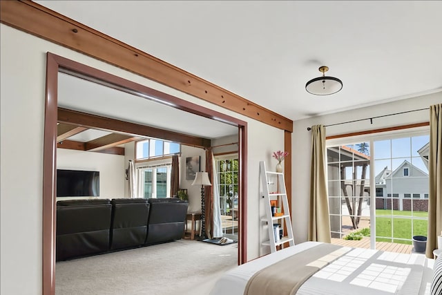 bedroom featuring carpet, beam ceiling, and access to exterior