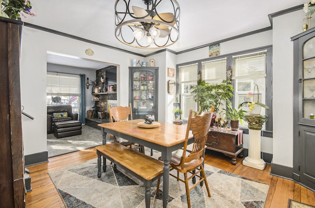 dining space with light wood-type flooring, crown molding, and a chandelier