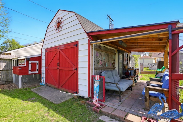 view of outbuilding featuring fence, an outbuilding, and an outdoor hangout area