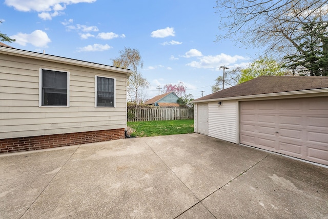 view of patio / terrace featuring a detached garage, fence, and an outdoor structure