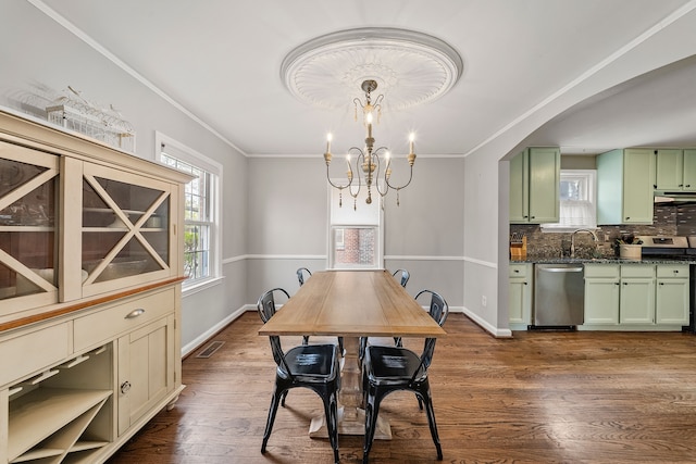 dining space featuring dark wood-style flooring, visible vents, ornamental molding, and baseboards