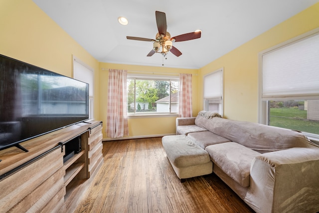 living room featuring wood finished floors, a ceiling fan, and baseboards