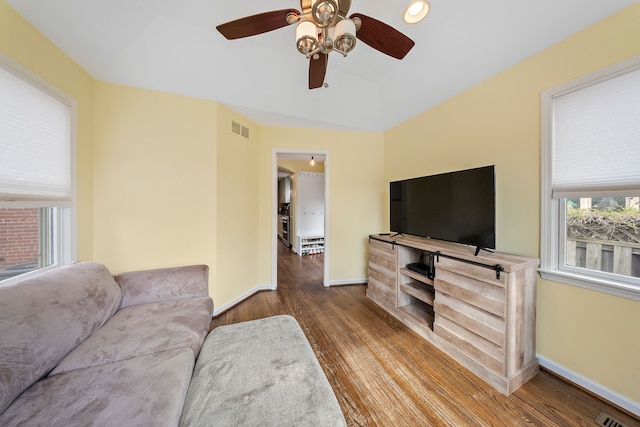 living area featuring wood finished floors, visible vents, ceiling fan, and baseboards