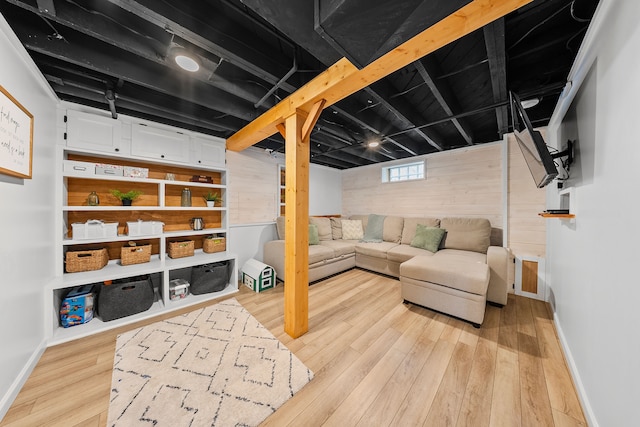 interior space with wood walls, light wood-style floors, and baseboards