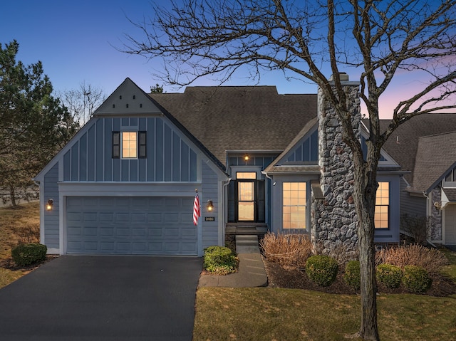 craftsman-style house featuring board and batten siding, a chimney, a shingled roof, and aphalt driveway