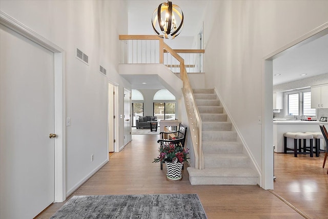 foyer with a notable chandelier, visible vents, a healthy amount of sunlight, and light wood-type flooring