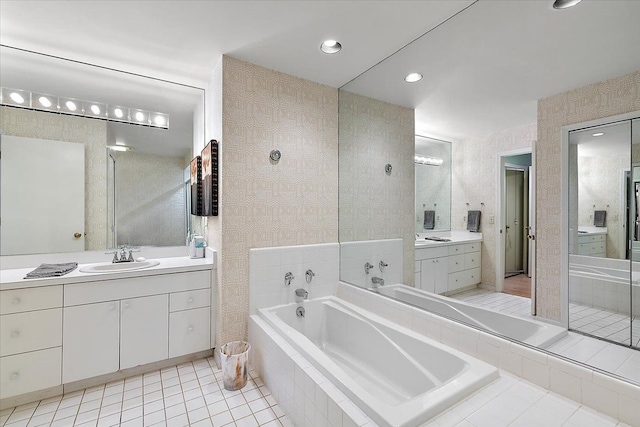 bathroom featuring a bath, tile patterned flooring, two vanities, a sink, and recessed lighting