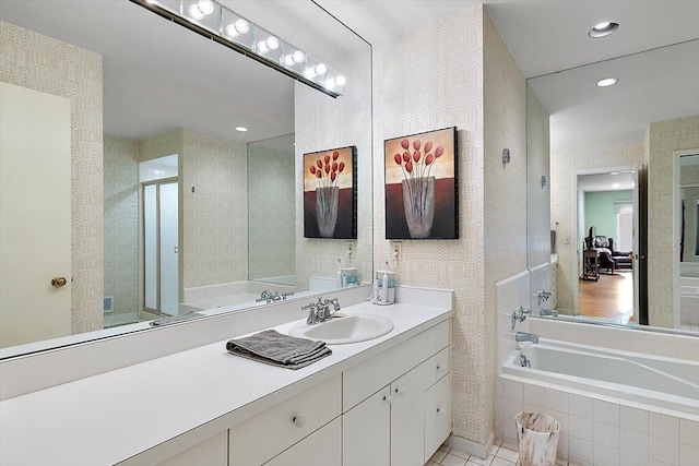 full bath with recessed lighting, vanity, a garden tub, and a stall shower