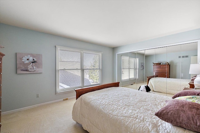 bedroom with baseboards, light carpet, and visible vents