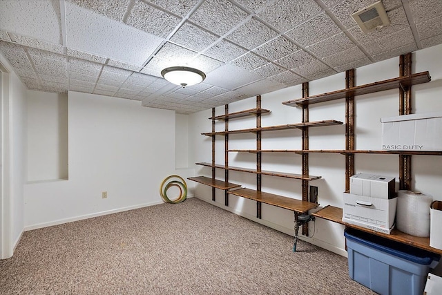 basement featuring baseboards, carpet, and visible vents
