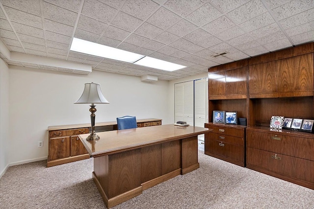 home office with baseboards, light colored carpet, a paneled ceiling, and visible vents