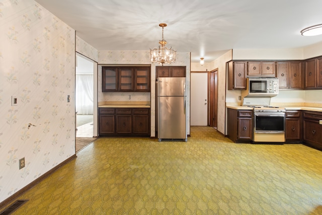 15895 Bexley St, Clinton Township, MI 48038 - kitchen with a chandelier, wallpapered walls, appliances with stainless steel finishes, light countertops, and baseboards