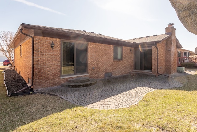 15895 Bexley St, Clinton Township, MI 48038 - back of house featuring a patio, a lawn, a chimney, and brick siding