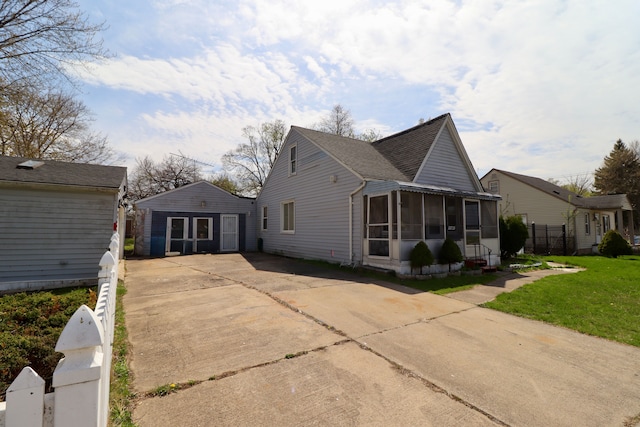 view of side of home with a lawn, a sunroom, fence, concrete driveway, and a shingled roof