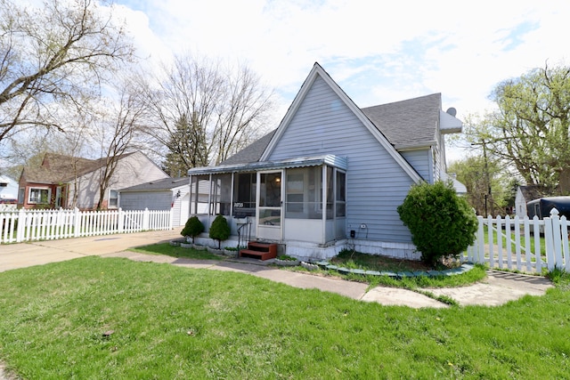 bungalow-style home with roof with shingles, a front yard, a sunroom, fence, and entry steps