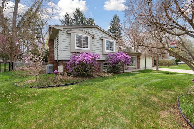 view of front of house with fence, brick siding, a garage, a front yard, and central AC unit
