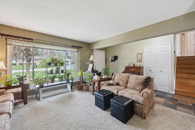 carpeted living room featuring stairs
