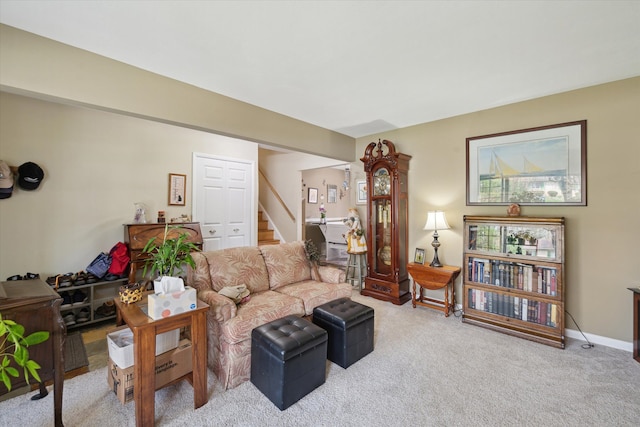 living room featuring baseboards, carpet, and stairs