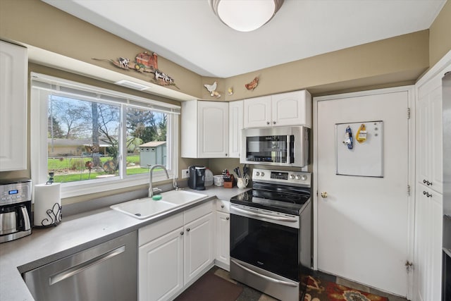 kitchen featuring visible vents, light countertops, white cabinets, a sink, and stainless steel appliances
