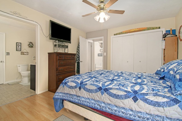 bedroom featuring connected bathroom, baseboards, a closet, wood finished floors, and a ceiling fan