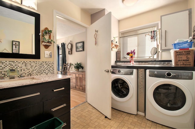 laundry room with washing machine and dryer, a sink, brick patterned floor, and laundry area