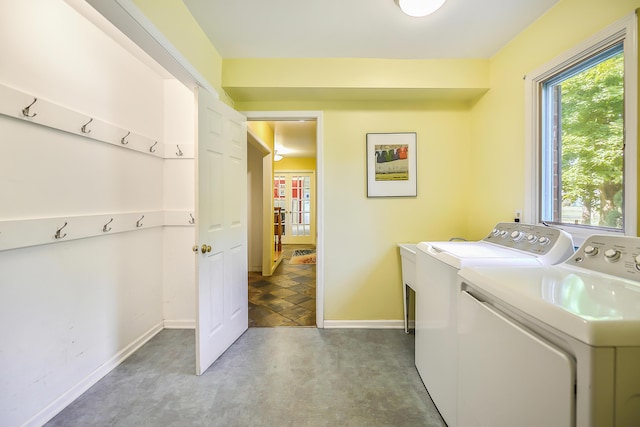 washroom with washing machine and clothes dryer, laundry area, and baseboards