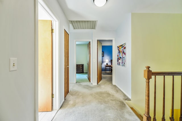 hallway featuring light carpet and baseboards