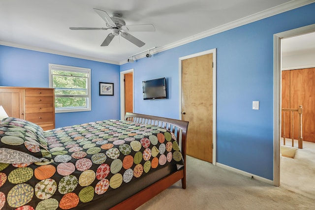 bedroom with baseboards, ceiling fan, crown molding, and carpet flooring