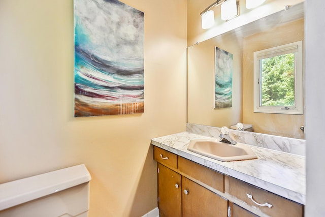 bathroom featuring vanity, toilet, and baseboards