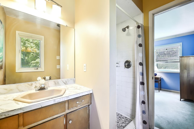 bathroom featuring tiled shower and vanity