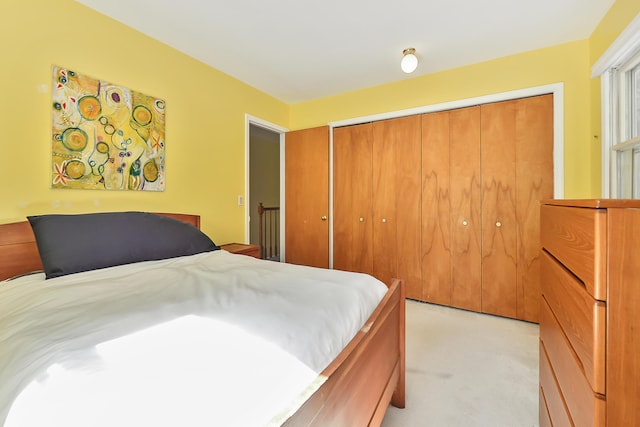 bedroom featuring light colored carpet and a closet