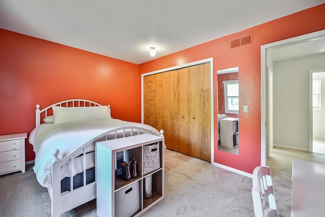 bedroom featuring light colored carpet, visible vents, baseboards, and a closet