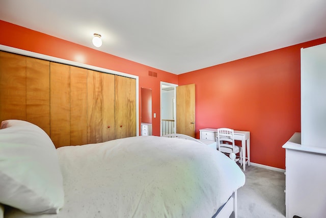 carpeted bedroom featuring visible vents, baseboards, and a closet