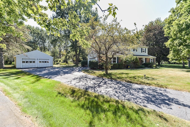 view of front of property with a detached garage, an outdoor structure, and a front lawn