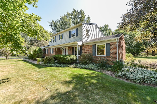 traditional-style house with a front yard and brick siding