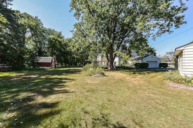 view of yard with an outdoor structure, a shed, and a garage