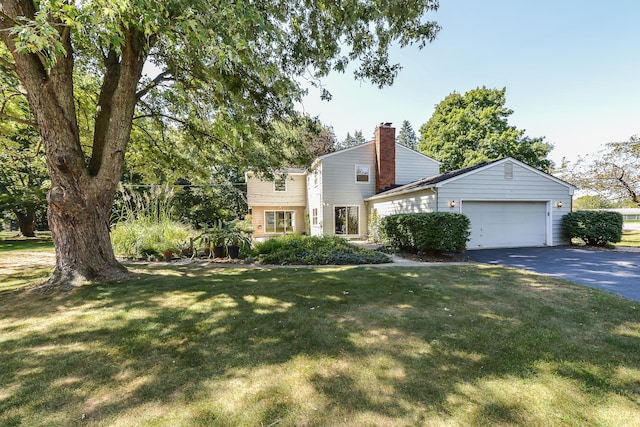 view of front facade featuring a front lawn, a chimney, a garage, and aphalt driveway