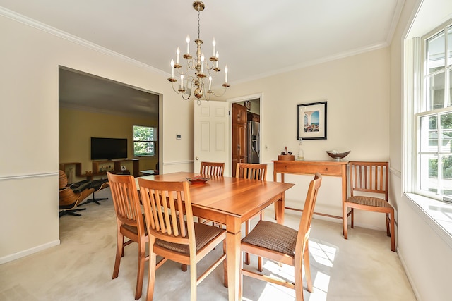 dining area featuring crown molding, a chandelier, light colored carpet, and baseboards