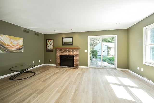 unfurnished living room with visible vents, light wood-style flooring, and a healthy amount of sunlight