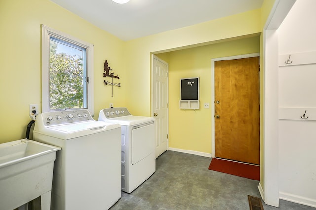 laundry area featuring laundry area, a sink, baseboards, visible vents, and washing machine and dryer