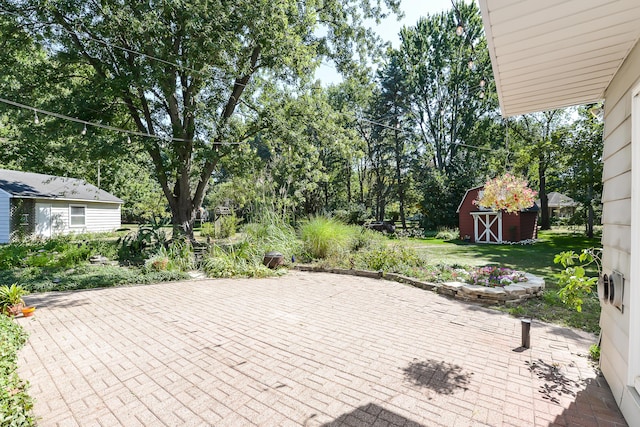 deck with a patio, a storage unit, and an outdoor structure