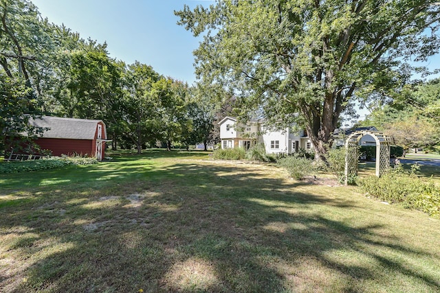 view of yard featuring a storage shed and an outbuilding