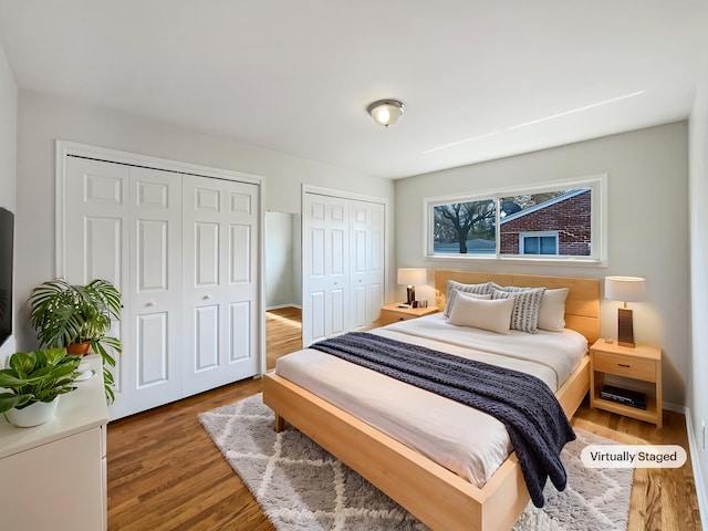 bedroom featuring two closets and wood finished floors